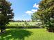 Beautiful golf course view from backyard, showcasing lush green grass and mature trees at 10653 Belfry Cir, Orlando, FL 32832