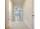 Inviting hallway features neutral tile flooring, leading to a bright living area with a large window at 10653 Belfry Cir, Orlando, FL 32832