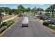 Community entrance featuring palm trees, manicured landscaping, and a security gate for controlled access at 1115 Deer Creek Blvd, Davenport, FL 33837
