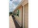 A beige home's exterior with green shutters, brick walkway, and a white awning at 1115 Deer Creek Blvd, Davenport, FL 33837