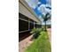 A screened in patio with a brick floor, and white trim, with a green lawn and landscaping next to the home at 1115 Deer Creek Blvd, Davenport, FL 33837