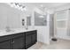 Modern bathroom featuring a double vanity, glass shower, and bright natural light at 1156 Cavender Creek Rd, Minneola, FL 34715