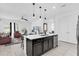 Modern kitchen with a black island and stainless steel appliances flowing into the living room at 1156 Cavender Creek Rd, Minneola, FL 34715