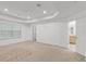 Bright bedroom featuring carpet, tray ceilings, and doorways to the closet and bathroom at 11837 Cave Run Ave, Windermere, FL 34786