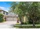Beautiful home exterior with mature trees, a brick driveway, and a two-car garage at 11837 Cave Run Ave, Windermere, FL 34786