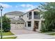 Exterior view of a two-story home with a balcony, two-car garage, and manicured landscaping at 11837 Cave Run Ave, Windermere, FL 34786