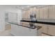 Modern kitchen with white cabinets, black countertops, and stainless steel appliances at 11837 Cave Run Ave, Windermere, FL 34786