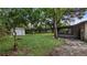 Backyard featuring a screened porch, a storage shed, a wooden fence, mature trees and a grassy lawn at 1209 Russell Dr, Ocoee, FL 34761
