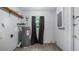 Utility room featuring a water heater, white block walls and a window framed with light-blocking curtains at 1209 Russell Dr, Ocoee, FL 34761