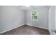Cozy bedroom featuring light gray walls, new flooring, and a bright window at 1209 Russell Dr, Ocoee, FL 34761