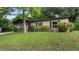 Cozy single-story house featuring a well-manicured front lawn and mature shade trees at 1209 Russell Dr, Ocoee, FL 34761