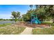Playground featuring a slide, climbing structure, and swing set, near a lake and mature trees at 1209 Russell Dr, Ocoee, FL 34761
