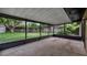 Screened porch with a concrete floor offering backyard view of mature trees, greenery and a storage shed at 1209 Russell Dr, Ocoee, FL 34761