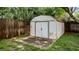 Outdoor storage shed with double doors and a concrete foundation along a wooden fence at 1209 Russell Dr, Ocoee, FL 34761