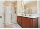 Well-lit bathroom features a glass-enclosed shower, double vanity, and neutral tones, creating a clean and functional space at 12884 Calderdale Ave, Windermere, FL 34786