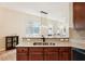 A lovely kitchen shows wood cabinets, granite countertops, stainless steel sink with a view to the living room at 12884 Calderdale Ave, Windermere, FL 34786