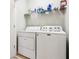 Practical laundry area equipped with a washing machine, dryer, and overhead shelving for storage at 12884 Calderdale Ave, Windermere, FL 34786
