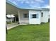 Charming single-story home featuring a carport, a small picket fence and blue trim details at 1401 W Highway 50 # 152, Clermont, FL 34711