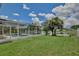 Scenic backyard featuring screened pool with lake view and well-maintained lawn at 14332 Grassy Cove Cir, Orlando, FL 32824