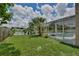 Grassy backyard with a view of the enclosed pool, palm trees, and a serene pond at 14332 Grassy Cove Cir, Orlando, FL 32824