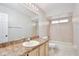 Bright bathroom featuring a shower, tub, and vanity with a large mirror and light fixture at 14332 Grassy Cove Cir, Orlando, FL 32824