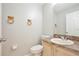 Cozy half-bathroom with a single sink vanity and decorative towel rings at 14332 Grassy Cove Cir, Orlando, FL 32824