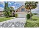 Inviting two-story home showcasing lush landscaping, a well-manicured lawn, and a convenient two-car garage at 14332 Grassy Cove Cir, Orlando, FL 32824