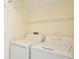 Laundry room featuring a washer, dryer, and wire shelf for convenient storage at 14332 Grassy Cove Cir, Orlando, FL 32824