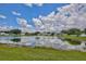 Community features a serene pond reflecting a beautiful sky surrounded by well-maintained homes at 14332 Grassy Cove Cir, Orlando, FL 32824