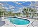 Screened-in pool and spa overlooking a pond and featuring palm trees at 14332 Grassy Cove Cir, Orlando, FL 32824
