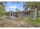 Back exterior view of home and landscaped yard with a patio and a sunroom at 14402 Sw 34Th Terrace Rd, Ocala, FL 34473