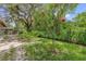 Landscaped backyard with a well-maintained lawn, mature trees, and decorative shrubs at 14402 Sw 34Th Terrace Rd, Ocala, FL 34473