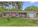 Charming single-story home featuring a brick facade, green siding, and a well-maintained front yard at 14402 Sw 34Th Terrace Rd, Ocala, FL 34473