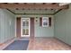Inviting covered front porch with tile flooring, green wood, and a screen door entry at 14402 Sw 34Th Terrace Rd, Ocala, FL 34473