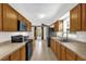 Functional kitchen with wooden cabinetry, modern appliances, and tile flooring at 14402 Sw 34Th Terrace Rd, Ocala, FL 34473
