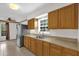 Close-up of a kitchen area with wooden cabinets, stainless steel sink, and neutral countertops at 14402 Sw 34Th Terrace Rd, Ocala, FL 34473