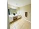 Bathroom with double vanity, a large mirror, and neutral tile flooring creating a serene atmosphere at 15258 Windmill Harbor Ct, Orlando, FL 32828