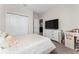 Bright bedroom featuring a patterned comforter, white dresser, and large television at 15716 Sweet Lemon Way, Winter Garden, FL 34787