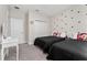 Bedroom featuring two twin beds with black bedding and Mickey Mouse pillows, plus a white closet and vanity at 15716 Sweet Lemon Way, Winter Garden, FL 34787
