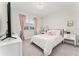 Bright bedroom with a polka dot comforter, a large window with pink drapes, and a vanity area at 15716 Sweet Lemon Way, Winter Garden, FL 34787