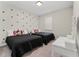 Bedroom featuring two twin beds with black bedding and Mickey Mouse pillows, plus a white vanity at 15716 Sweet Lemon Way, Winter Garden, FL 34787