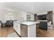 Bright, open kitchen featuring white cabinetry, stainless steel appliances, and an island with seating overlooking the living area at 15716 Sweet Lemon Way, Winter Garden, FL 34787