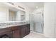 Bathroom featuring double sinks, granite countertops and a walk-in shower at 1864 Green Dragon Dr, St Cloud, FL 34771