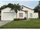 Charming single-story home featuring a well-manicured lawn, palm tree, and inviting front entrance at 2118 Donegan Pl, Orlando, FL 32826