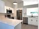 Modern kitchen features stainless steel appliances, white cabinets, and a bright window at 2118 Donegan Pl, Orlando, FL 32826