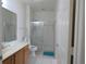 Clean bathroom with wood cabinets, tile flooring, glass shower door, and a toilet at 2406 Grand Central Pkwy # 14, Orlando, FL 32839