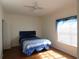 Bright bedroom features laminate flooring and a bed with blue patterned comforter set below a ceiling fan at 2406 Grand Central Pkwy # 14, Orlando, FL 32839