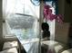 Dining area bathed in light featuring a glass table with tufted chairs and floral decor at 2406 Grand Central Pkwy # 14, Orlando, FL 32839