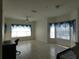 Bright living room featuring tile flooring and large windows dressed with valances and mini blinds at 2406 Grand Central Pkwy # 14, Orlando, FL 32839