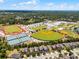 Aerial view of a school with athletic fields including baseball diamonds, tennis courts, and a track, near a residential area at 251 Domus Ln, Casselberry, FL 32707